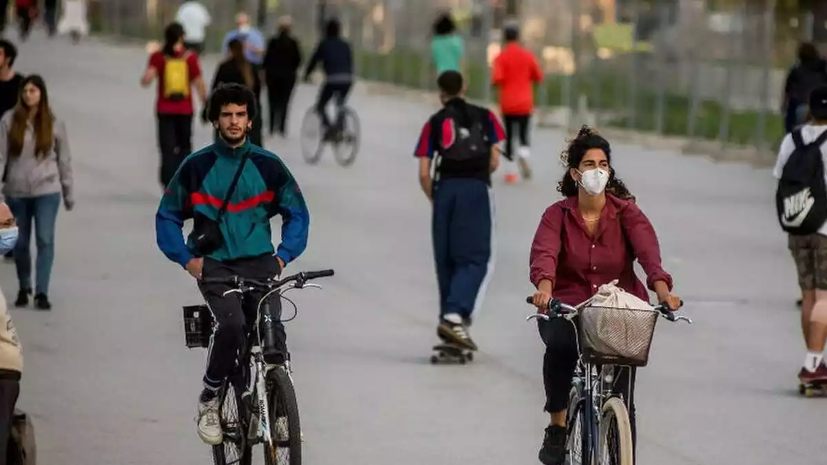 People outside walking or riding a bike in masks
