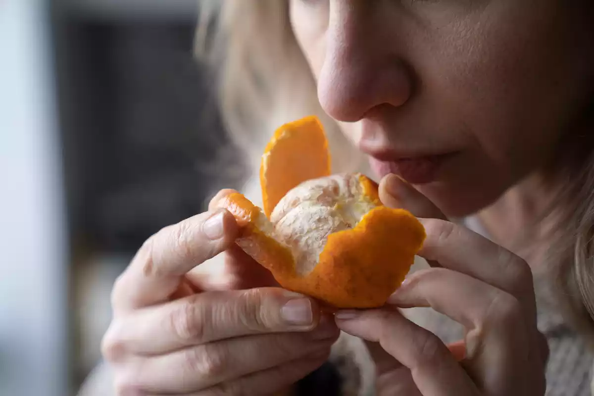 A woman smelling a mandarin