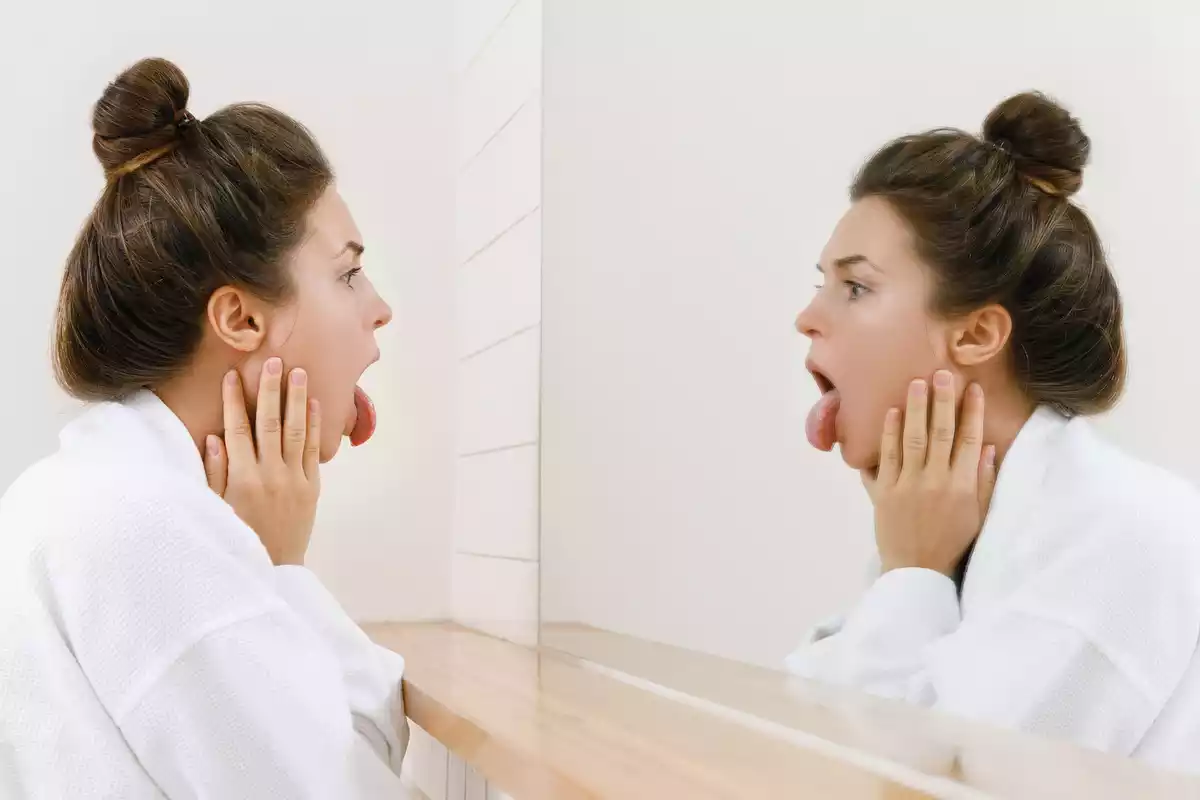 A woman looking in a mirror with her tongue out